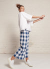 An indigo and white gingham, loose fitting crop pants with elasticated waistband and tie belt of the same fabric made from large gingham yarn dye washed linen