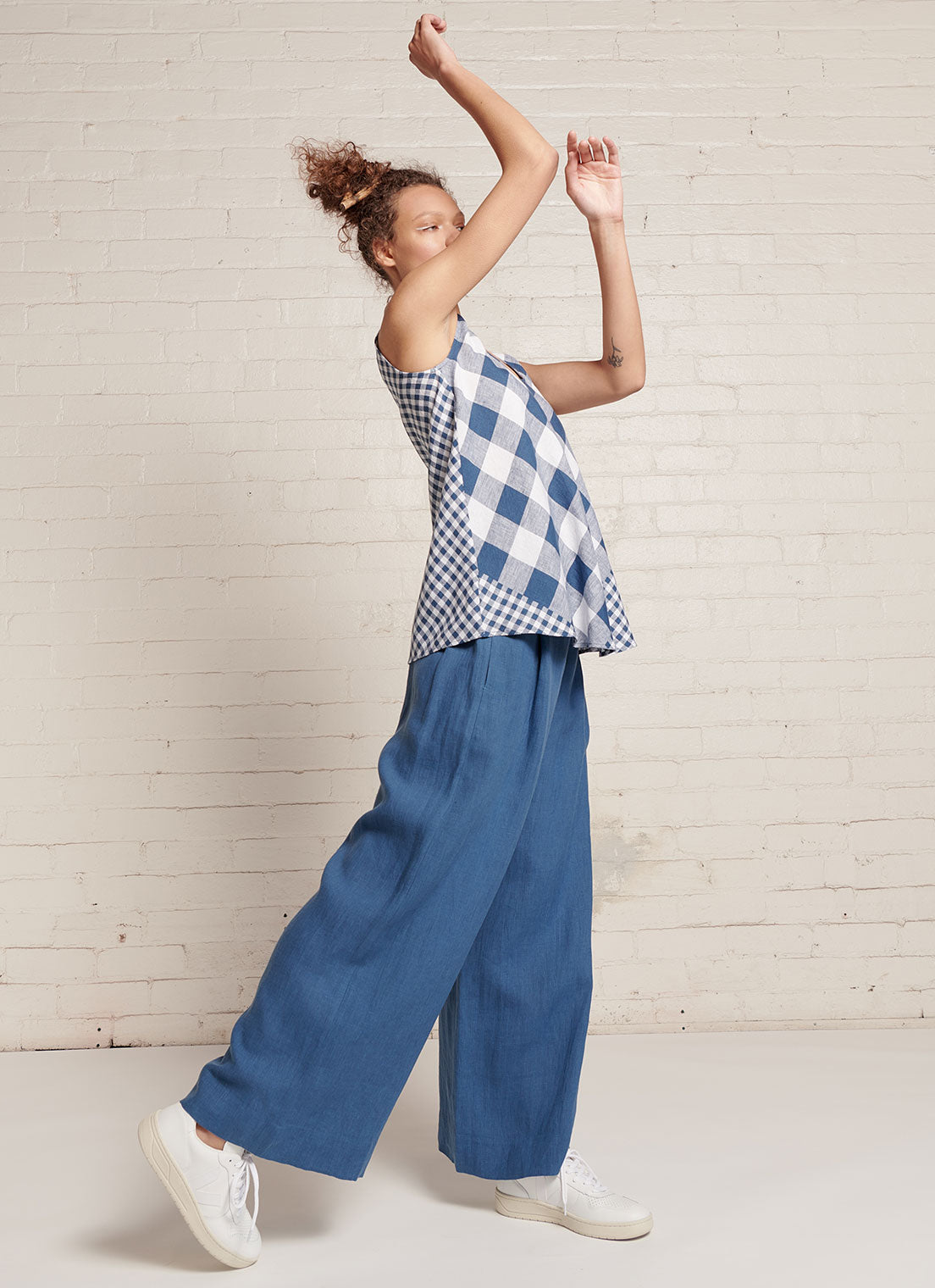 An indigo and white gingham, sleeveless tank top with round neckline made from mixed gingham yarn dye washed linen