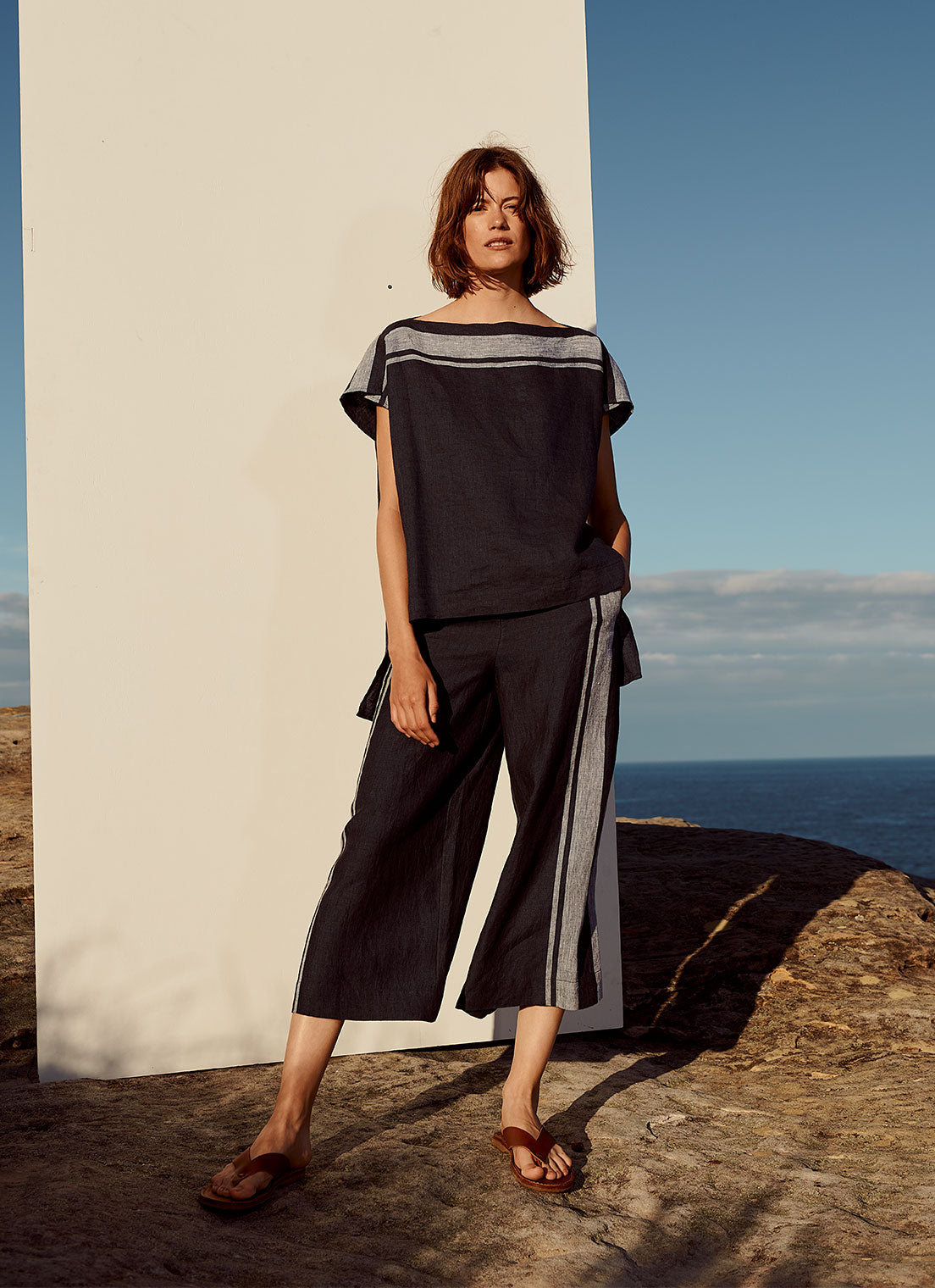 A cropped pant with drawstring waistband and side pockets made from yarn dye stripe washed linen in ink with pale blue stripe