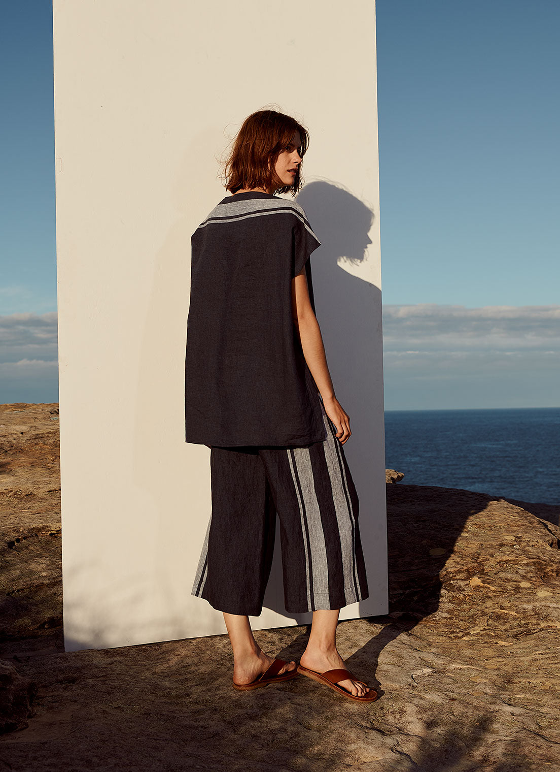 A cropped pant with drawstring waistband and side pockets made from yarn dye stripe washed linen in ink with pale blue stripe