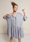 A denim, easy fit, knee-length, square-cut dress with open neckline, 3/4 sleeves, and gathered detailing made from yarn dye washed linen