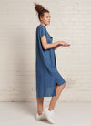 An indigo, knee-length linen dress with short sleeves, open neckline and centre front pleat detail made from yarn dye washed linen