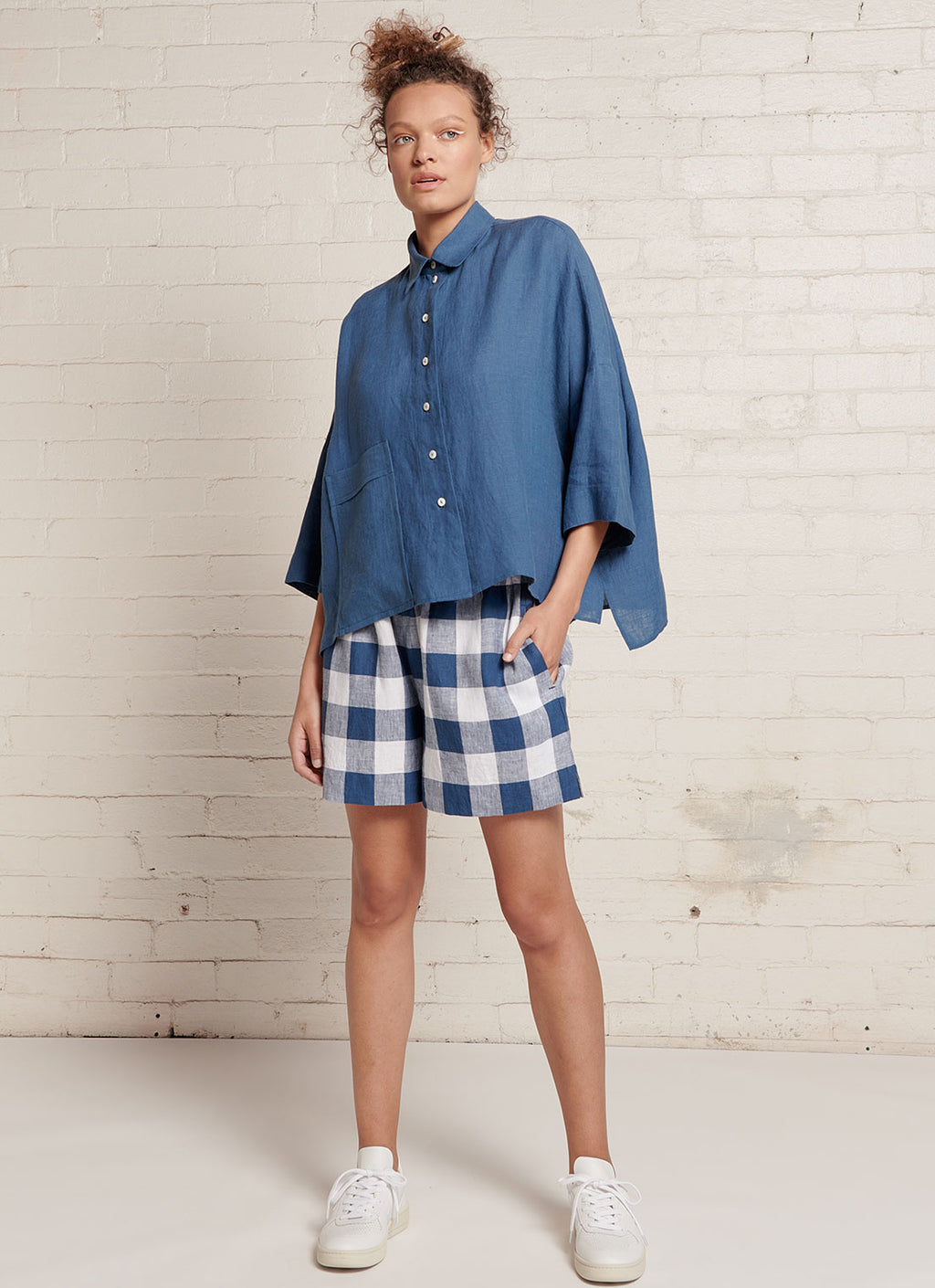 An indigo and white gingham shorts with elasticated waistband and pockets made from large gingham yarn dye washed linen