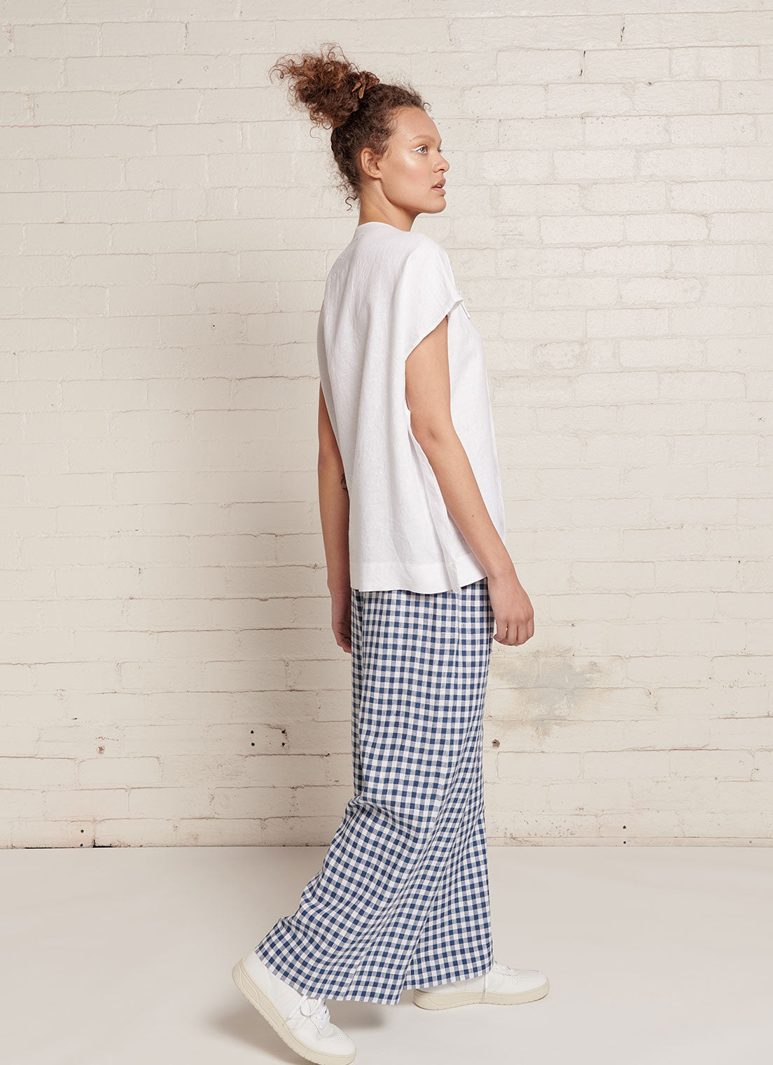 An indigo and white gingham, wide-leg pants with wide and elasticated back waistband and side pockets in small gingham yarn dye washed linen