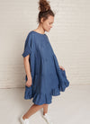 An indigo, easy fit, knee-length, tiered dress with round neckline, short sleeves, tie closures at the back made from yarn dye washed linen