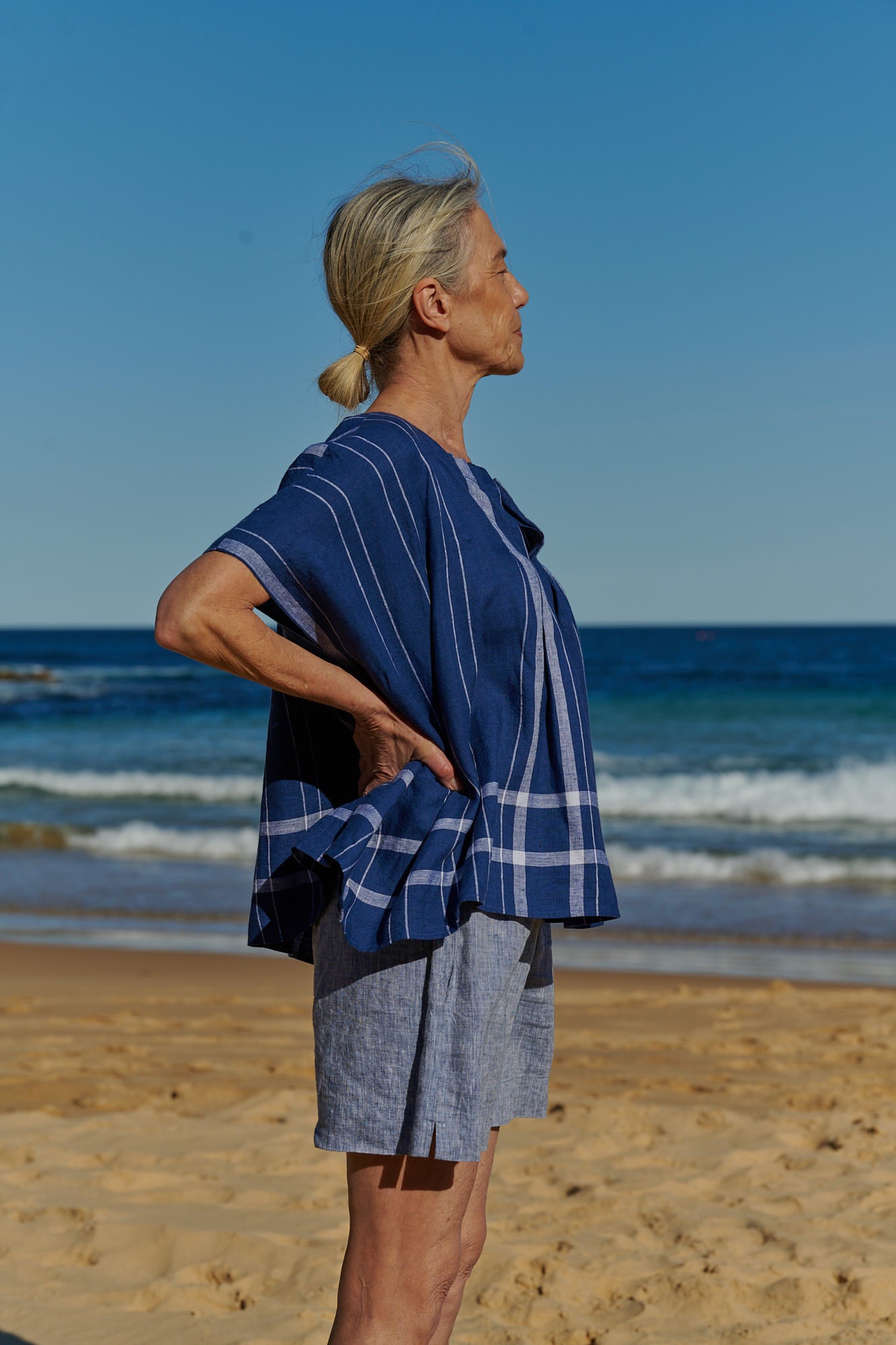 An indigo plaid, one size, easy fit linen top with pleat and tuck detail at the round neckline