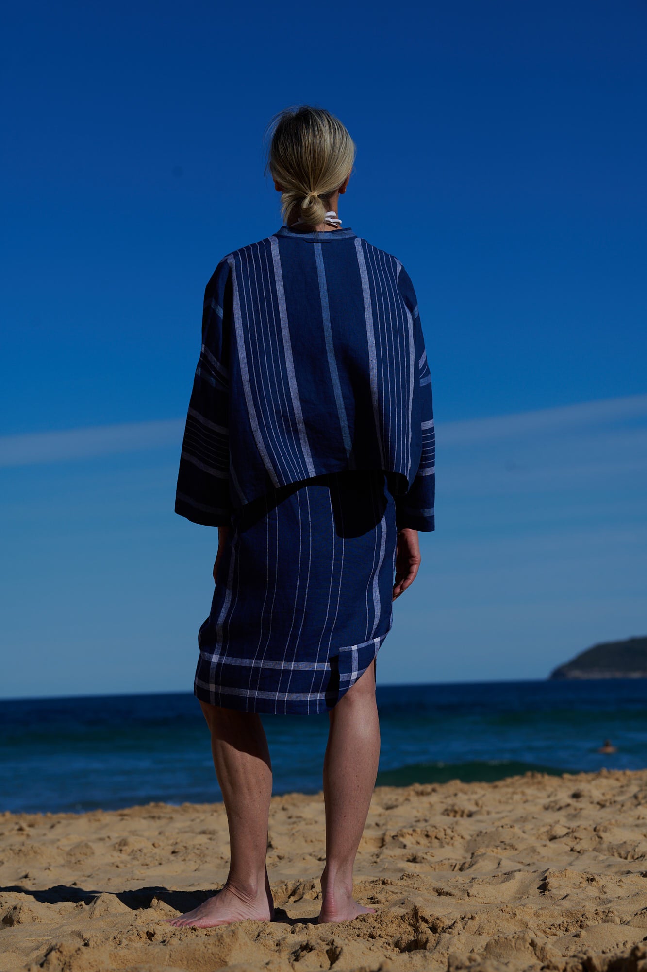 An indigo plaid linen, wrap around, knee-length skirt with waist ties and one side pocket