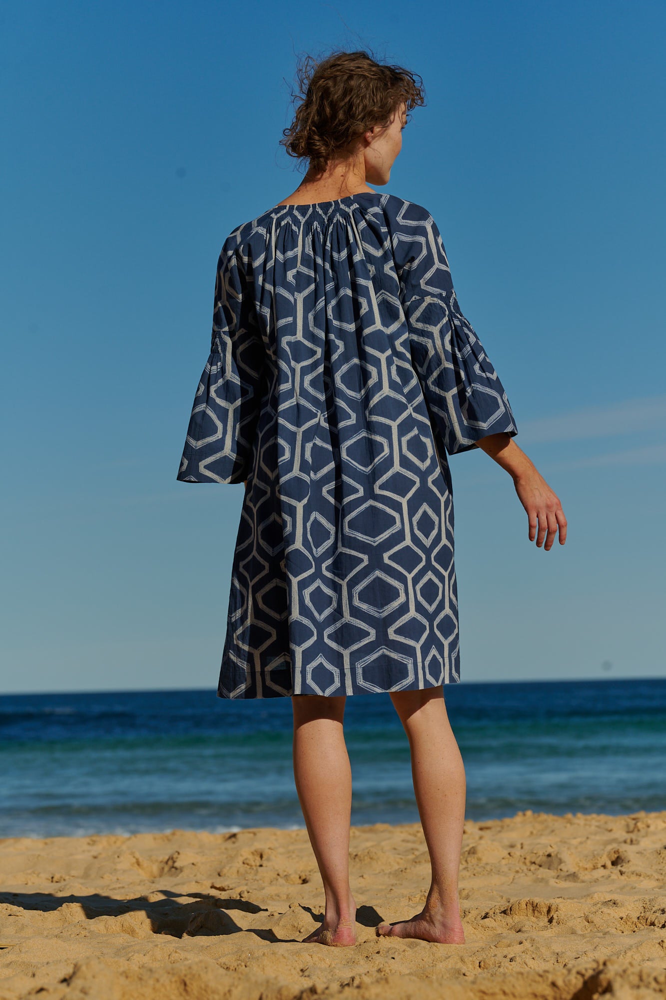 An easy fit, indigo shibori-dyed cotton dress with raglan bell sleeves and ruched detail at neckline
