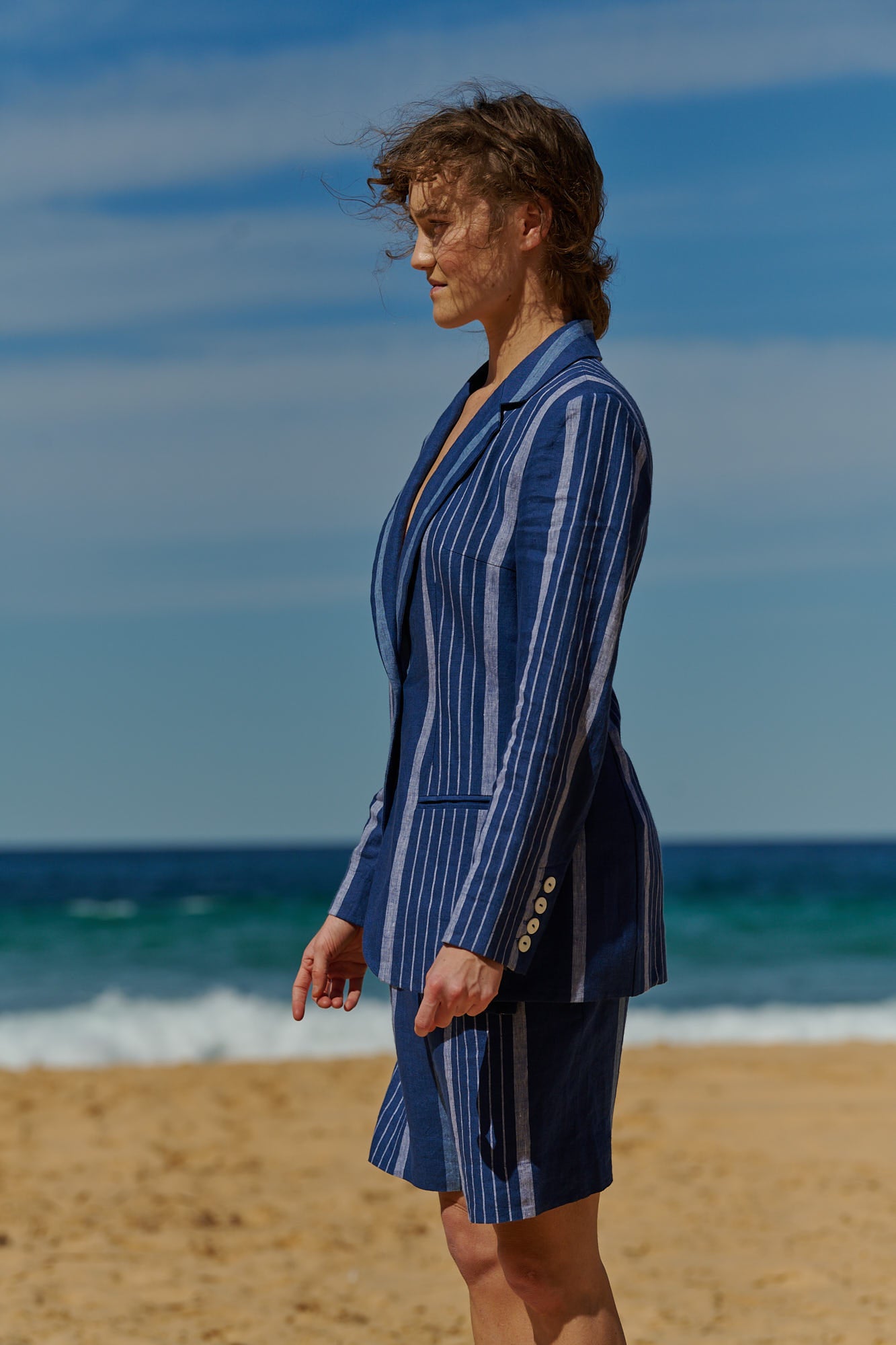 An indigo stripe relaxed linen short with wide and elasticated waistband, pockets and belt of the same fabric