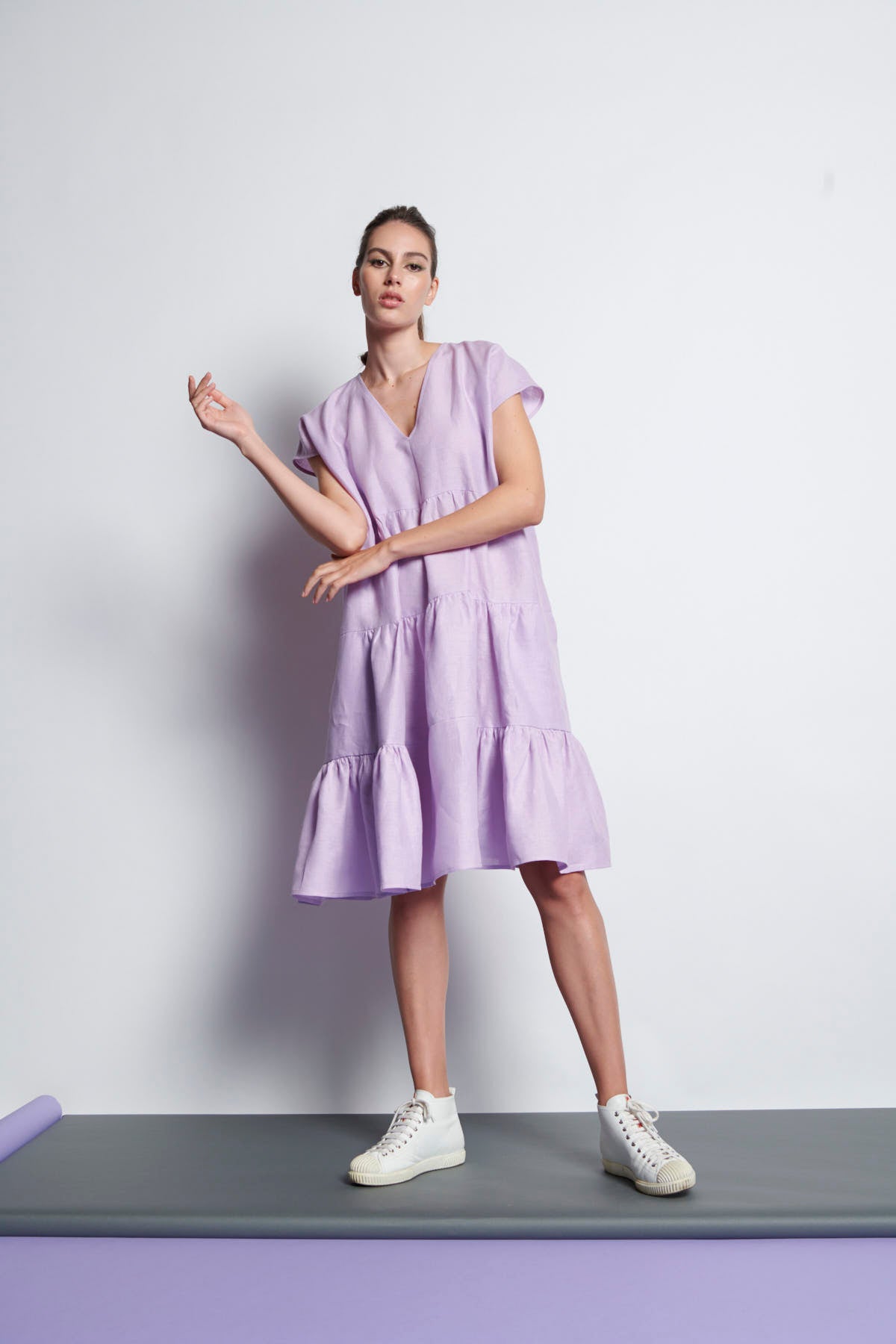 A lilac V-neckline, knee-length tiered dress with short sleeves made from pure linen