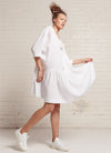 A white, easy fit, knee-length, square-cut dress with open neckline, 3/4 sleeves, and gathered detailing made from yarn dye washed linen