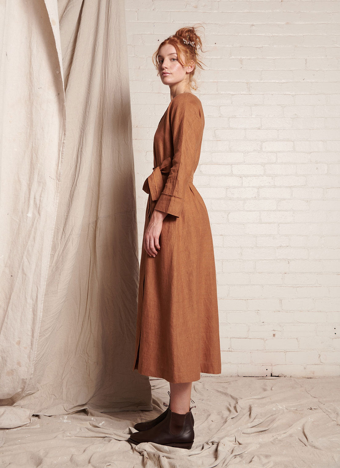 A bronze, wrap, midi-length dress with open, square-cut neckline and long, cuffed sleeves with hand frayed edge finish made from European linen