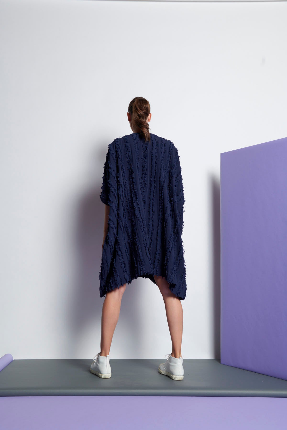 A navy blue easy fit, square cut, knee-length dress made from cotton and linen with round neckline, short sleeves, and striped fringe fabric