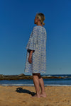 An easy fit, light blue shibori-dyed cotton dress with raglan bell sleeves and ruched detail at neckline