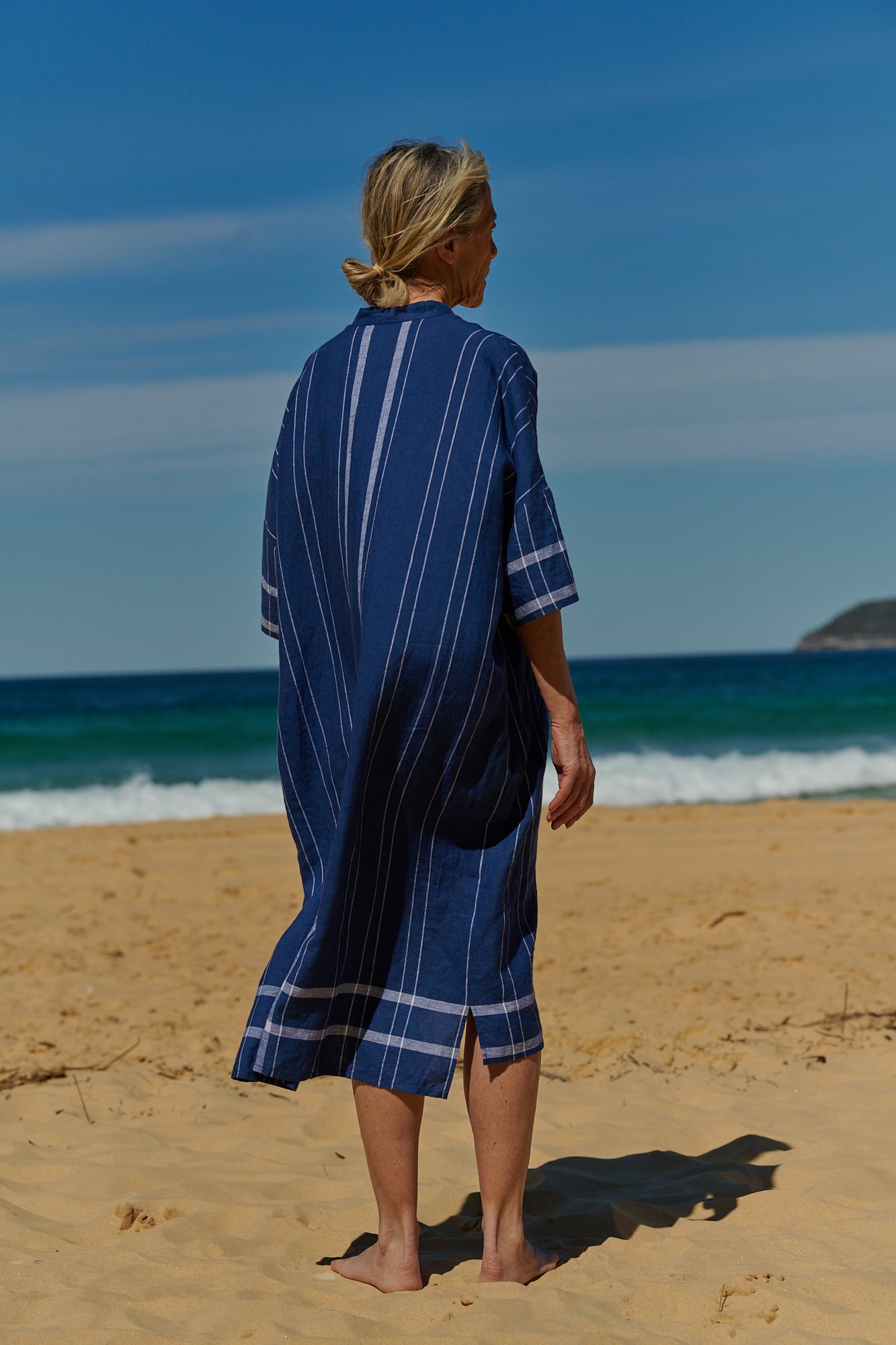 A one size, easy fit, midi-length plaid linen indigo shirtmaker dress with short sleeves