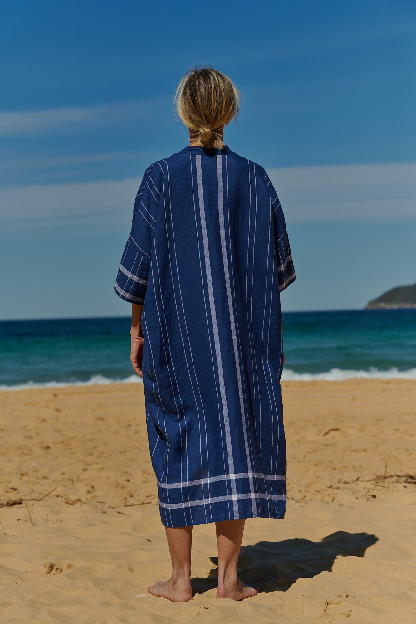 A one size, easy fit, midi-length plaid linen indigo shirtmaker dress with short sleeves
