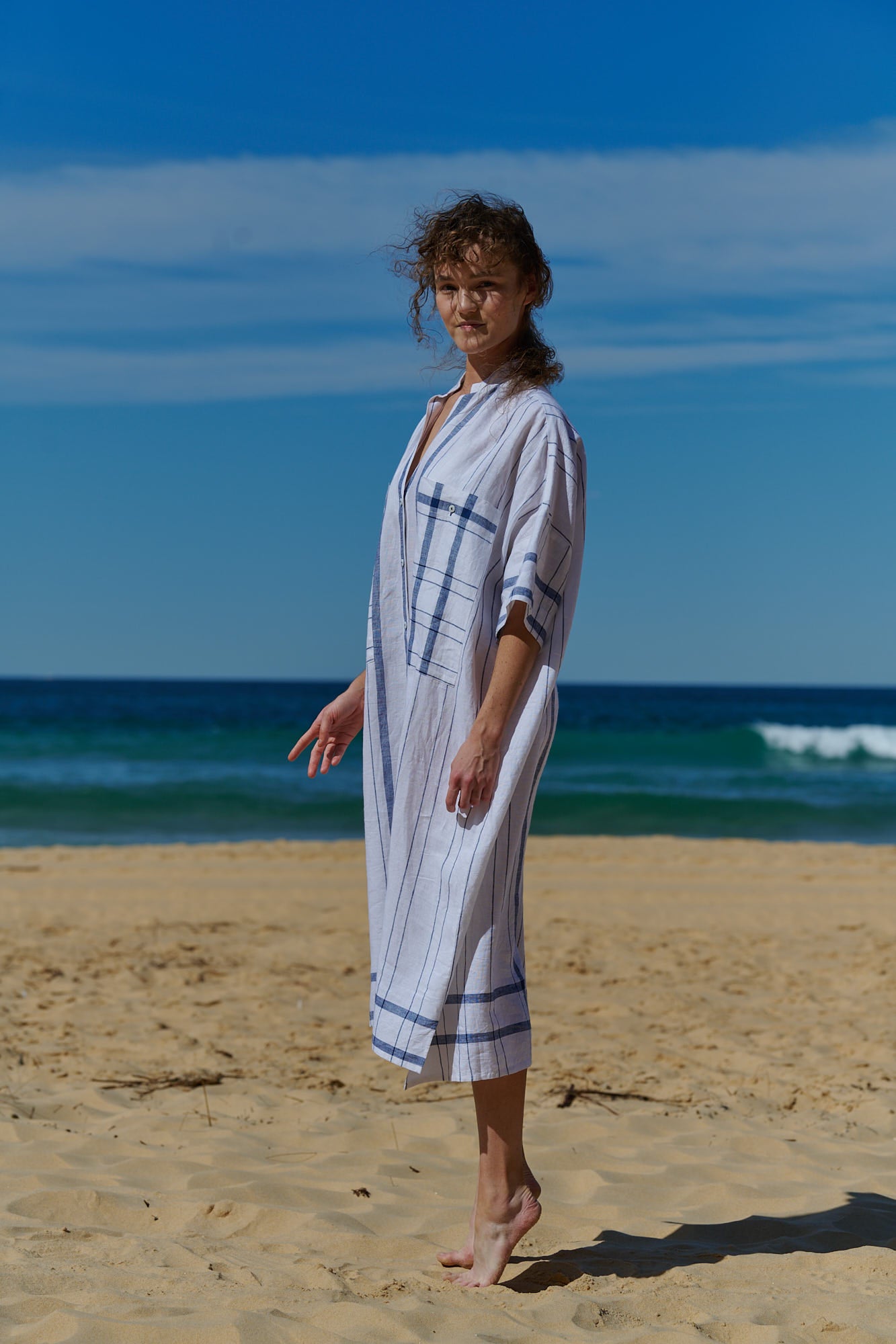 A one size, easy fit, midi-length plaid linen white shirtdress with short sleeves
