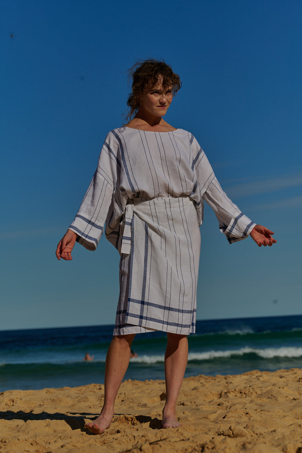 An easy fit, one size, double plaid white linen top with round neckline and long sleeves