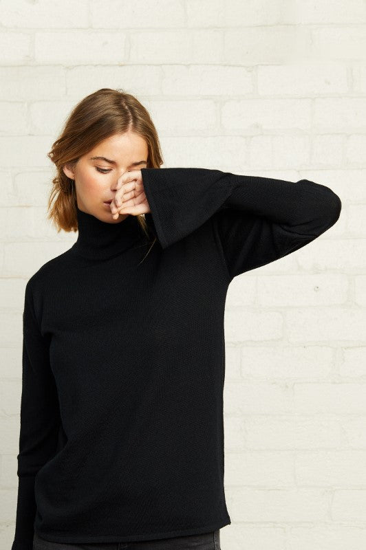 An Australian pure merino wool knit in black with a turtleneck and long bell sleeves