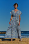 A flowy, pale blue, hand-dyed shibori cotton maxi dress with short sleeves and tie belt