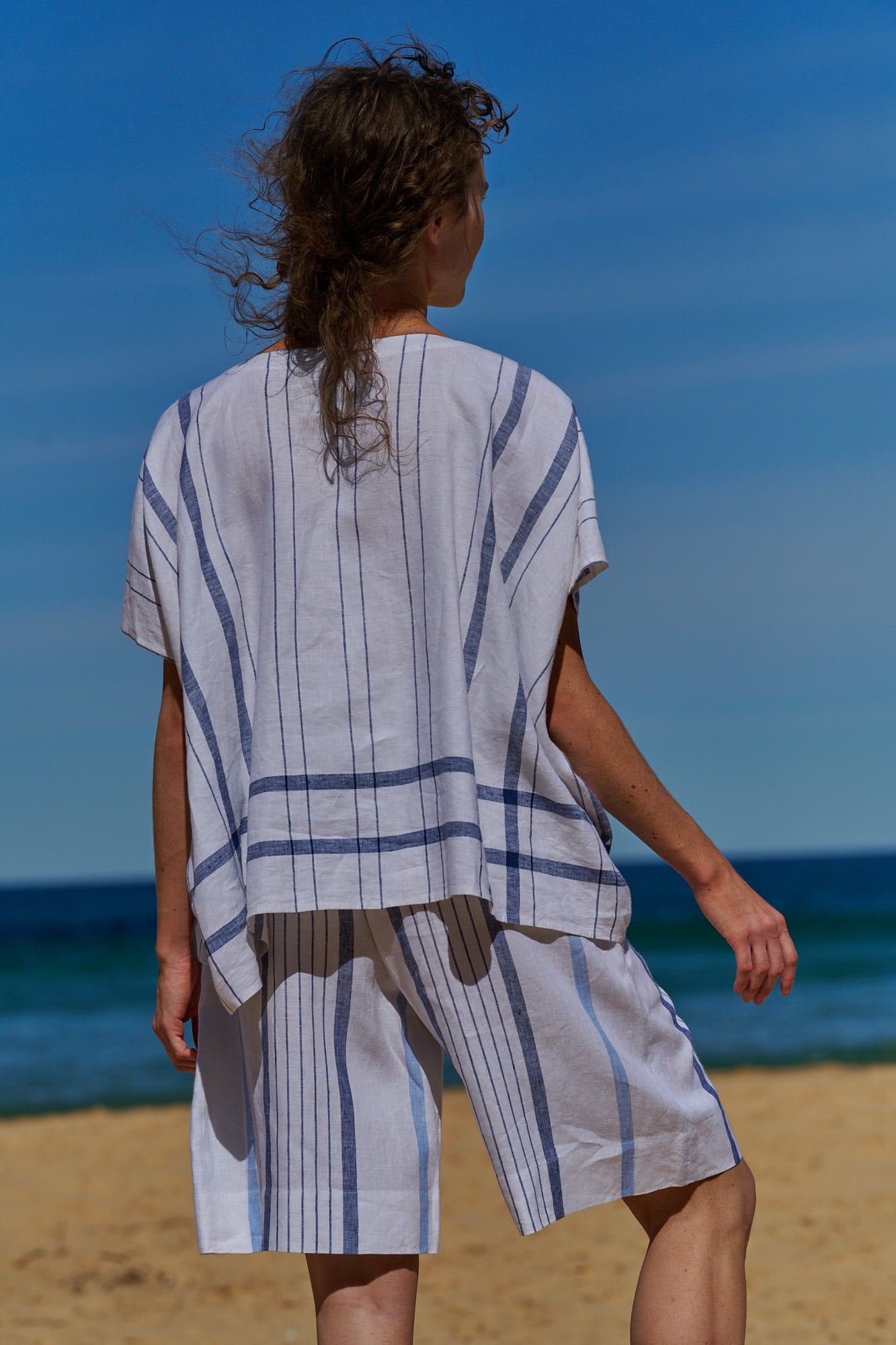 A white plaid, one size, easy fit linen top with pleat and tuck detail at the round neckline