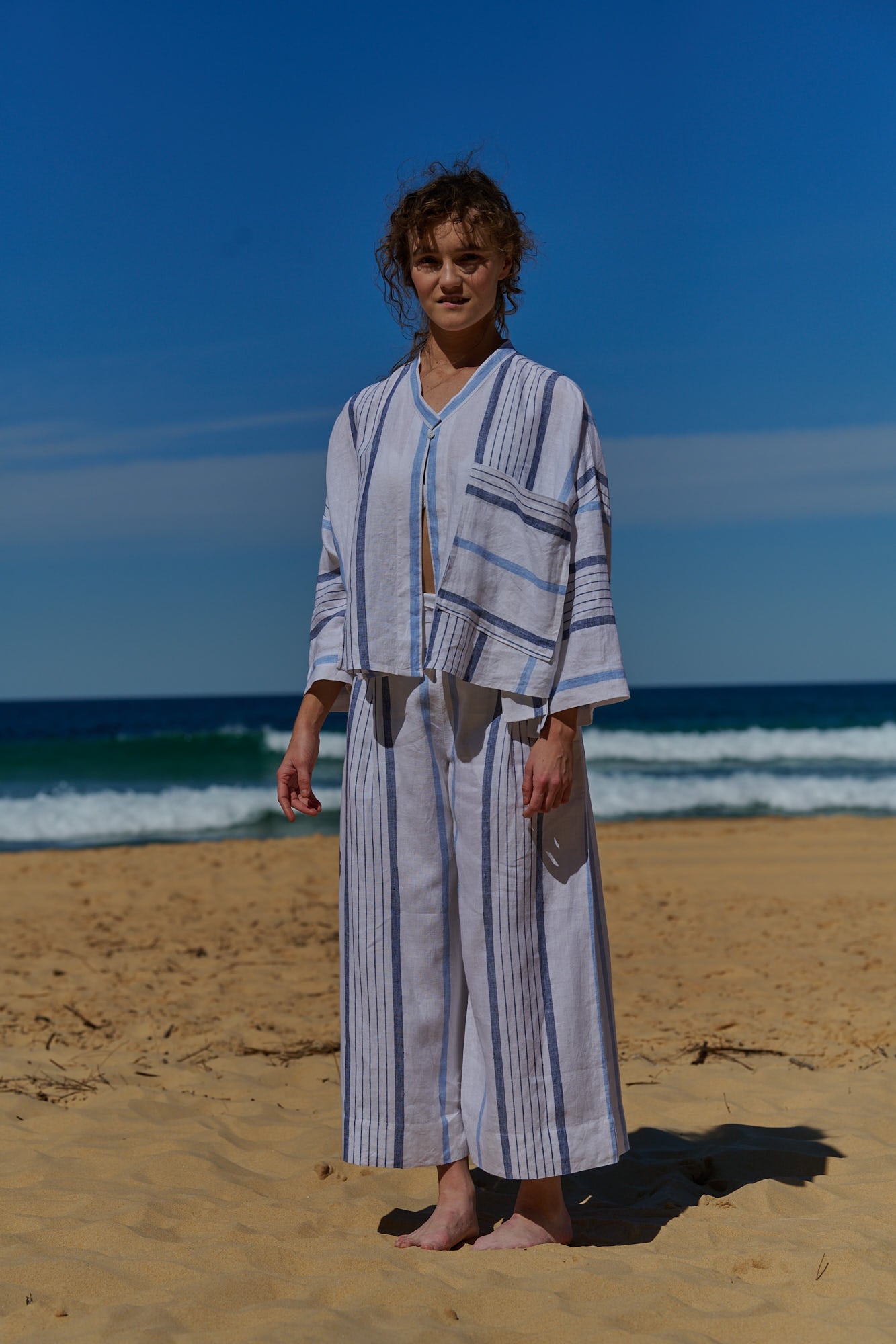 A white stripe linen, cropped pants with a wide, elasticised waistband, belt of the same fabric and pockets